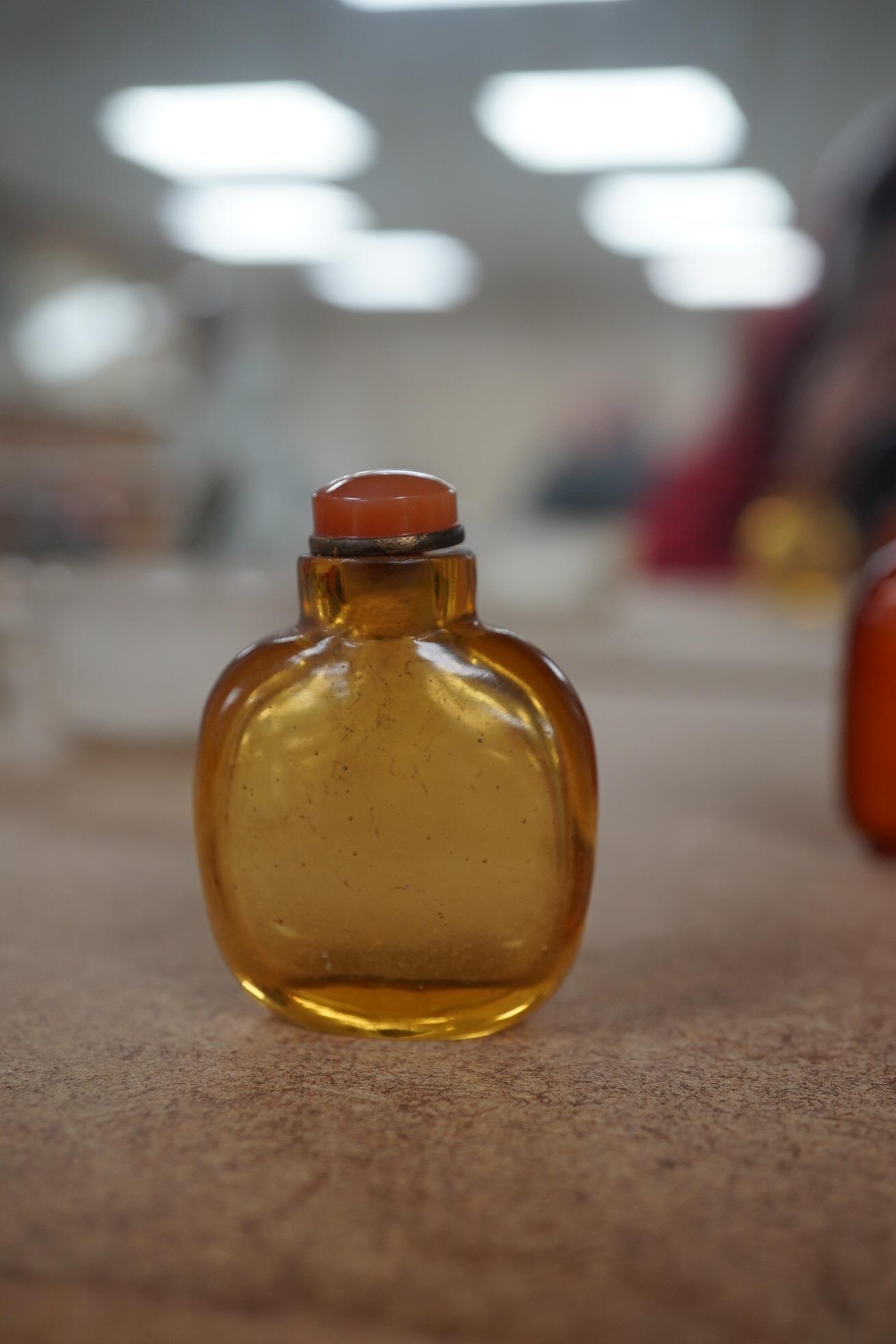 Two Chinese snuff bottles, amber and orange glass, and a similar bowenite bowl, 8cm. Condition - fair